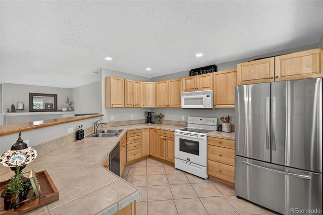 20854 State Highway 96, Wetmore, CO 81253 - kitchen featuring appliances with stainless steel finishes, light brown cabinetry, a textured ceiling, recessed lighting, and light tile patterned flooring