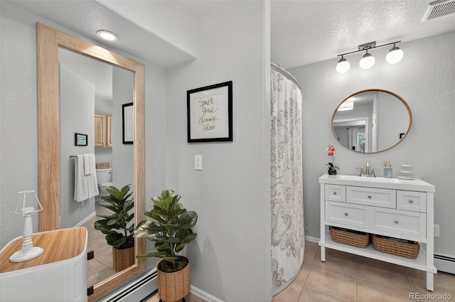 20854 State Highway 96, Wetmore, CO 81253 - full bath with tile patterned flooring, vanity, track lighting, a textured ceiling, and a baseboard radiator