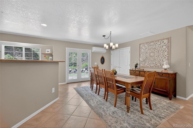 20854 State Highway 96, Wetmore, CO 81253 - dining space featuring a wall unit AC, light tile patterned floors, a chandelier, a textured ceiling, and french doors