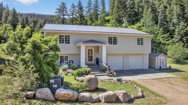 20854 State Highway 96, Wetmore, CO 81253 - bi-level home featuring driveway, a garage, a wooded view, a shed, and a metal roof