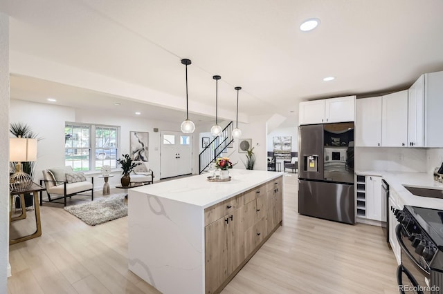 3374 S Niagara Way, Denver, CO 80224 - kitchen featuring stainless steel refrigerator with ice dispenser, black range with electric cooktop, a center island, light stone countertops, and light wood-style flooring