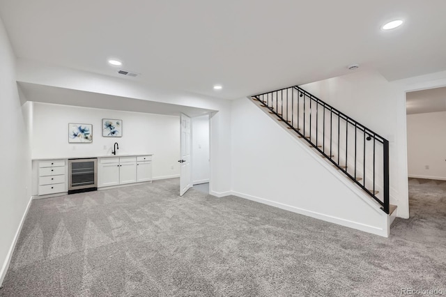 3374 S Niagara Way, Denver, CO 80224 - unfurnished living room with beverage cooler, light colored carpet, bar with sink, stairway, and recessed lighting