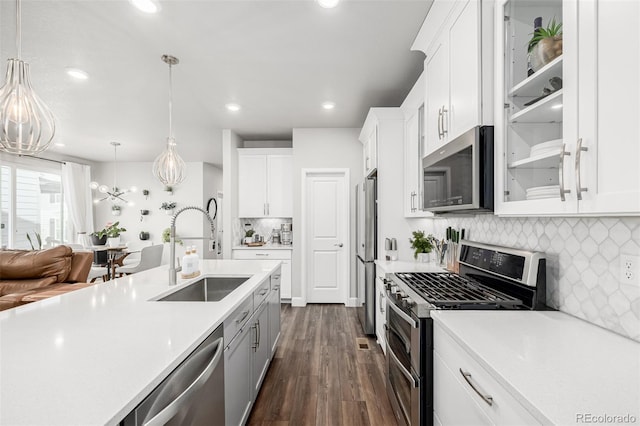 8358 Howell St Unit B, Arvada, CO 80005 - kitchen featuring stainless steel appliances, light countertops, white cabinetry, decorative backsplash, and dark wood-type flooring