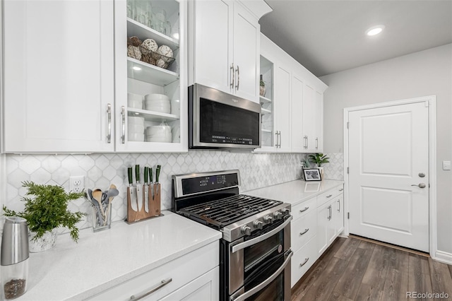 8358 Howell St Unit B, Arvada, CO 80005 - kitchen with stainless steel appliances, glass insert cabinets, light countertops, white cabinets, and dark wood-type flooring