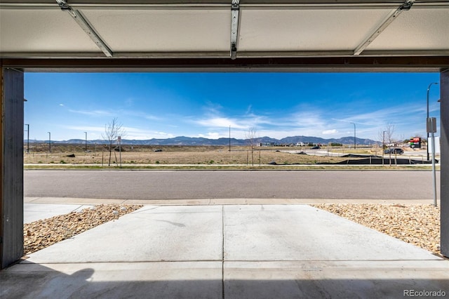 8358 Howell St Unit B, Arvada, CO 80005 - view of concrete driveway featuring a mountain view and street lighting