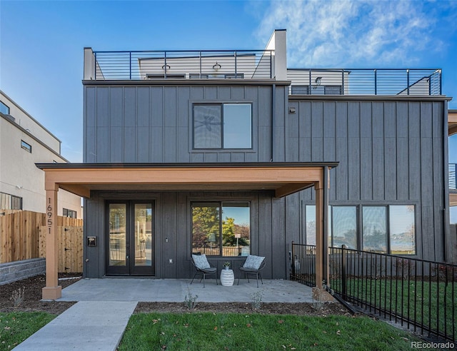 rear view of house featuring a patio, a yard, and a balcony