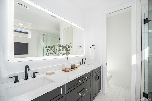 bathroom featuring vanity, an enclosed shower, and toilet