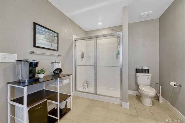 bathroom with an enclosed shower, tile patterned floors, and toilet