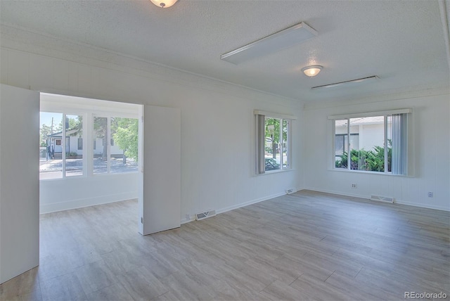 5723 Zephyr St, Arvada, CO 80002 - spare room with a textured ceiling, healthy amount of natural light, wood finished floors, baseboards, and crown molding