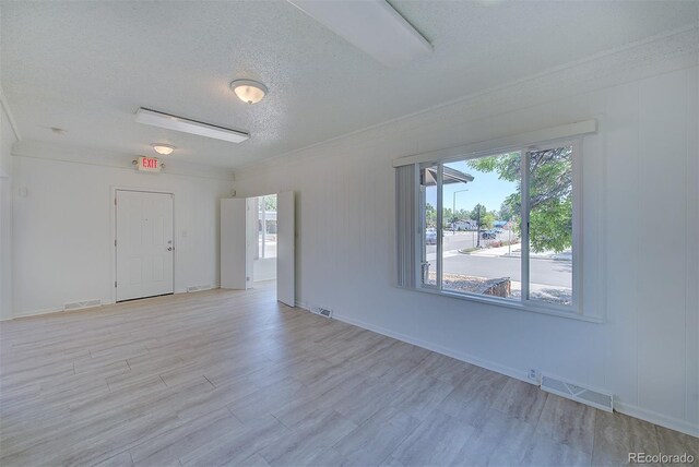 5723 Zephyr St, Arvada, CO 80002 - empty room with a textured ceiling, light wood-style flooring, crown molding, and baseboards