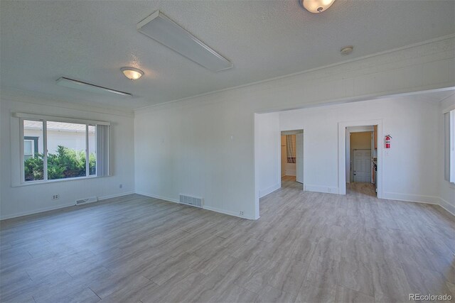 5723 Zephyr St, Arvada, CO 80002 - spare room featuring a textured ceiling, crown molding, light wood-style floors, and baseboards