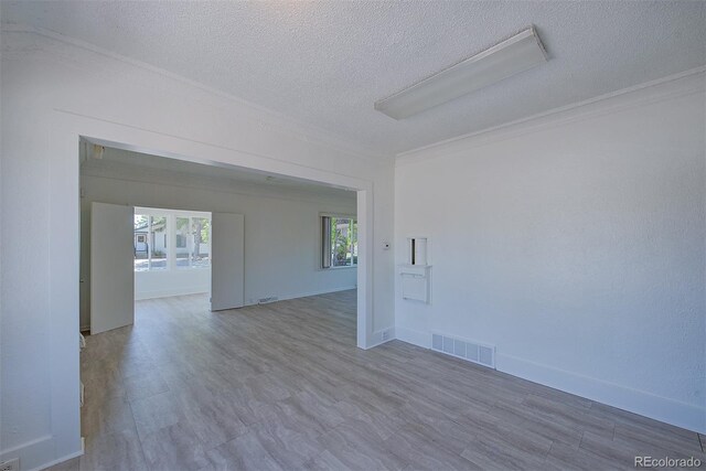 5723 Zephyr St, Arvada, CO 80002 - spare room featuring a textured ceiling, ornamental molding, baseboards, and wood finished floors