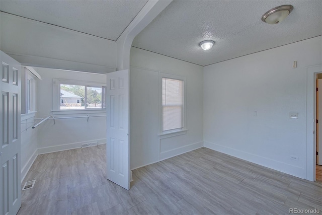 5723 Zephyr St, Arvada, CO 80002 - unfurnished room featuring a textured ceiling, light wood-style flooring, baseboards, and arched walkways