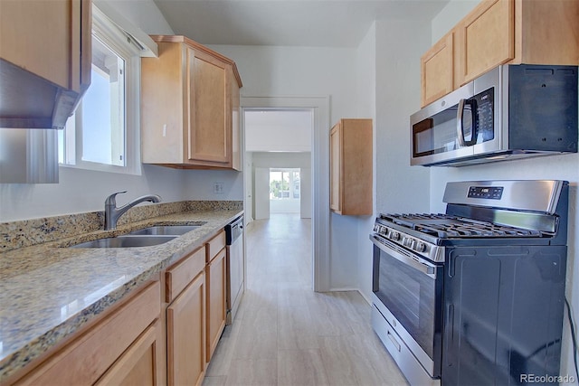 5723 Zephyr St, Arvada, CO 80002 - kitchen featuring appliances with stainless steel finishes, a sink, light brown cabinetry, light stone counters, and baseboards