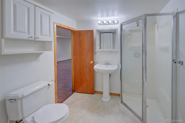 5723 Zephyr St, Arvada, CO 80002 - full bath featuring a shower stall, toilet, a textured ceiling, a sink, and a baseboard radiator