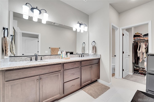 bathroom with tile patterned flooring, vanity, and toilet