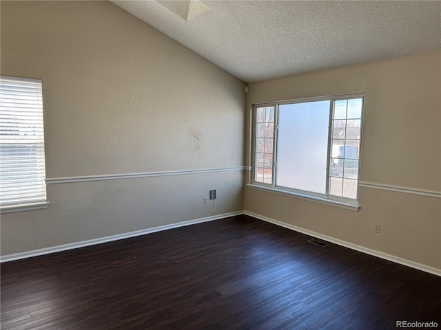 unfurnished room with dark hardwood / wood-style flooring, a textured ceiling, and lofted ceiling