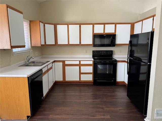 kitchen with dark hardwood / wood-style flooring, white cabinets, sink, and black appliances