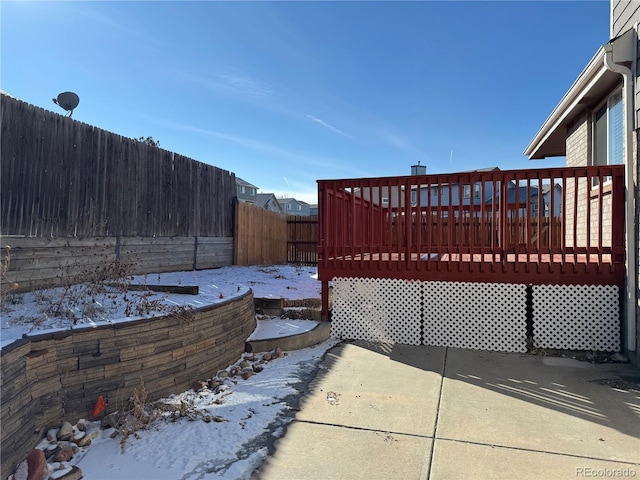 snow covered patio featuring a deck