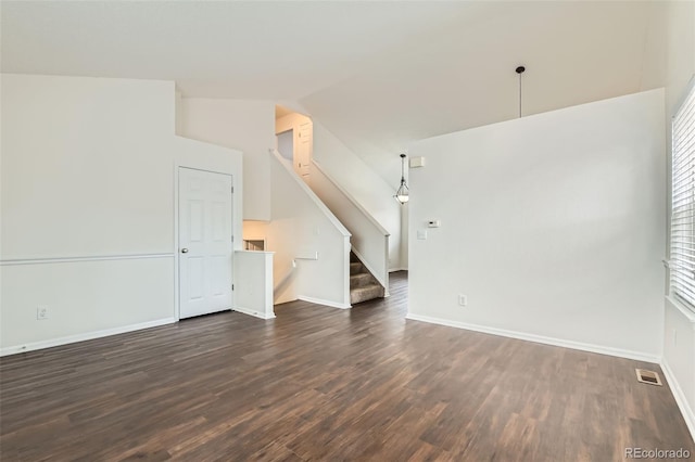 unfurnished living room featuring baseboards, dark wood finished floors, visible vents, vaulted ceiling, and stairway