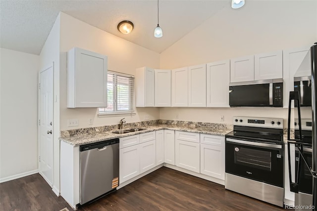 kitchen featuring a sink, stainless steel appliances, vaulted ceiling, dark wood-style floors, and light stone countertops