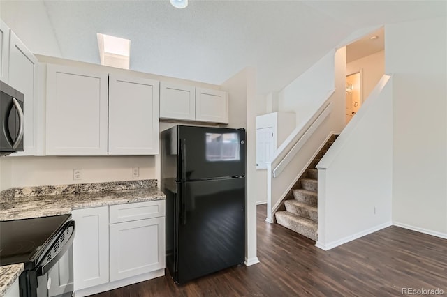 kitchen featuring white cabinets, light stone counters, dark wood-style flooring, and black appliances