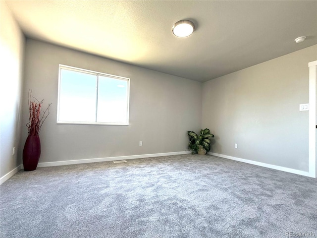 carpeted empty room with baseboards and visible vents