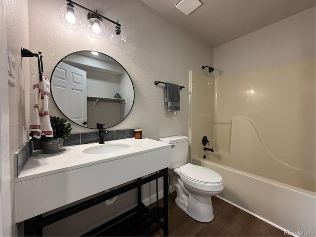 full bath featuring vanity, wood finished floors, bathing tub / shower combination, and toilet