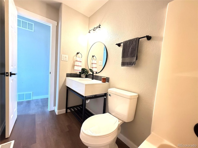 bathroom featuring toilet, visible vents, and wood finished floors