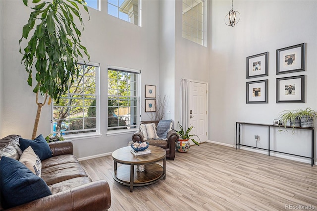 6039 S Ukraine Cir, Aurora, CO 80015 - living room featuring plenty of natural light, baseboards, light wood-type flooring, and a towering ceiling