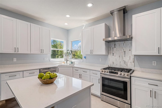 6039 S Ukraine Cir, Aurora, CO 80015 - kitchen featuring appliances with stainless steel finishes, wall chimney range hood, a sink, light countertops, and recessed lighting