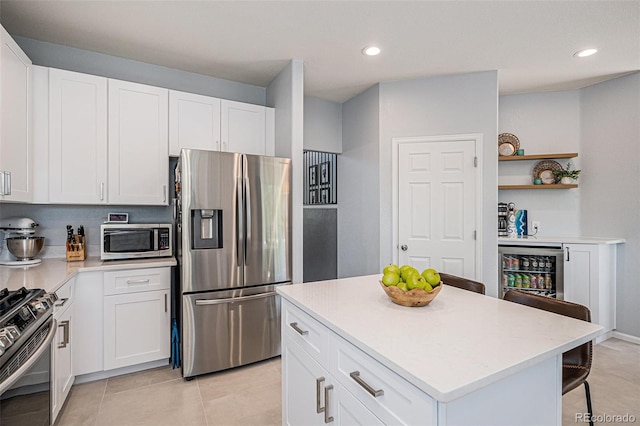 6039 S Ukraine Cir, Aurora, CO 80015 - kitchen with stainless steel appliances, wine cooler, open shelves, white cabinetry, and recessed lighting