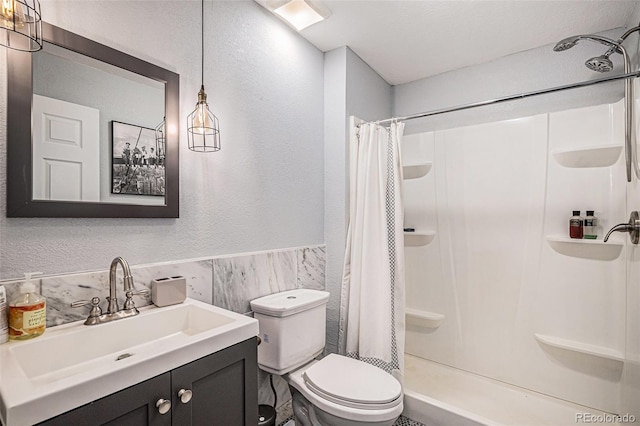 6039 S Ukraine Cir, Aurora, CO 80015 - full bathroom with toilet, vanity, curtained shower, a textured wall, and wainscoting