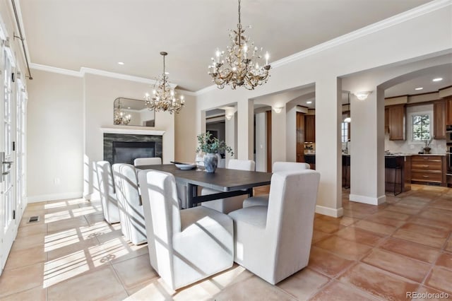 dining space with a high end fireplace, crown molding, baseboards, and light tile patterned floors