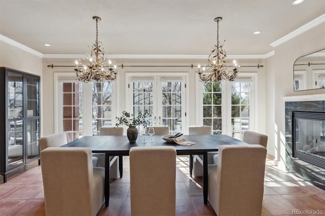 dining room with a fireplace, a chandelier, and crown molding