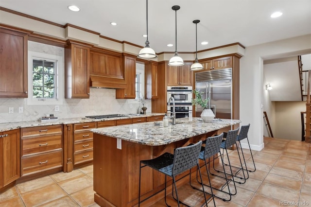 kitchen with stainless steel appliances, brown cabinets, a sink, and decorative backsplash