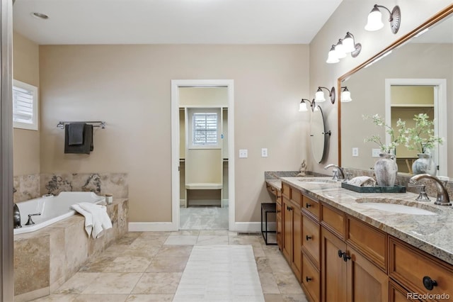 bathroom featuring double vanity, a sink, baseboards, and a bath