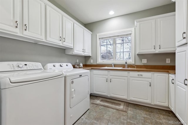 laundry area with cabinet space, washer and clothes dryer, a sink, and recessed lighting