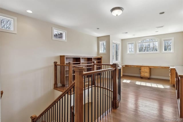 interior space featuring recessed lighting, an upstairs landing, baseboards, visible vents, and light wood-style floors