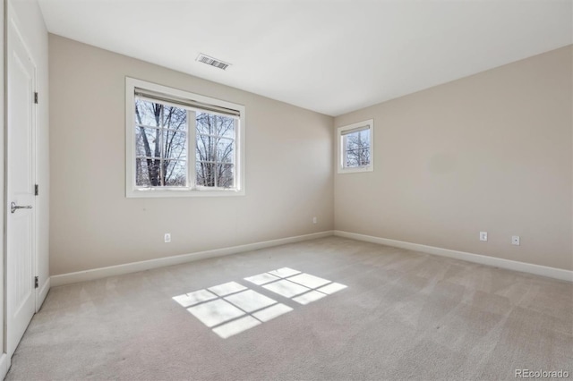 interior space featuring light colored carpet, visible vents, and baseboards