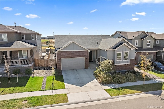 view of front of home featuring fence, a residential view, board and batten siding, concrete driveway, and brick siding