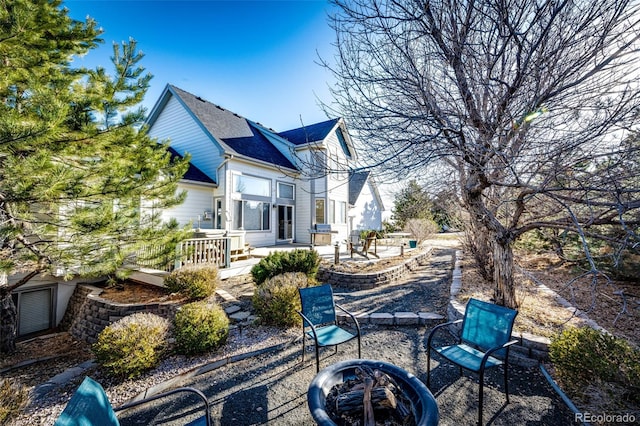 rear view of property with a fire pit and a patio area