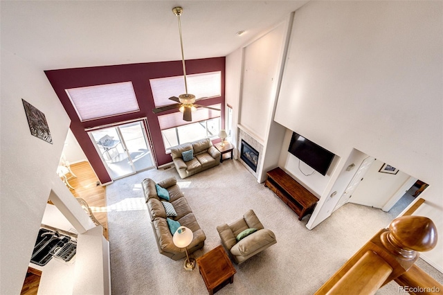 carpeted living room featuring ceiling fan and high vaulted ceiling