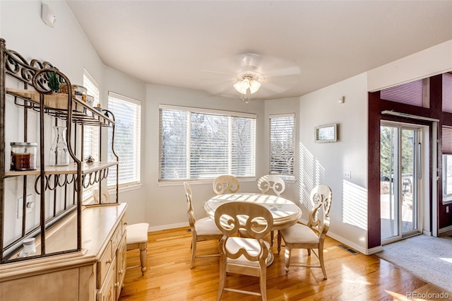 dining space with ceiling fan and light wood-type flooring