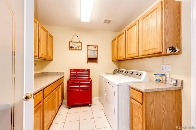 laundry area with cabinets, light tile patterned floors, and independent washer and dryer