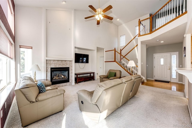 935 Green Gables Cir, Bennett, CO 80102 - carpeted living room featuring high vaulted ceiling, stairs, healthy amount of natural light, ceiling fan, and a fireplace