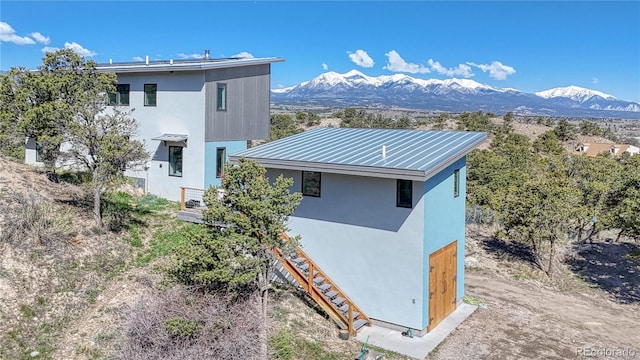 6644 County Road 110, Salida, CO 81201 - view of home's exterior featuring a mountain view, stucco siding, stairs, and a metal roof