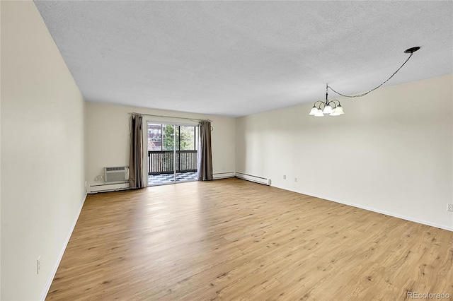 unfurnished room featuring light wood finished floors, a textured ceiling, and an inviting chandelier