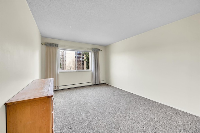 carpeted empty room with a textured ceiling and a baseboard heating unit