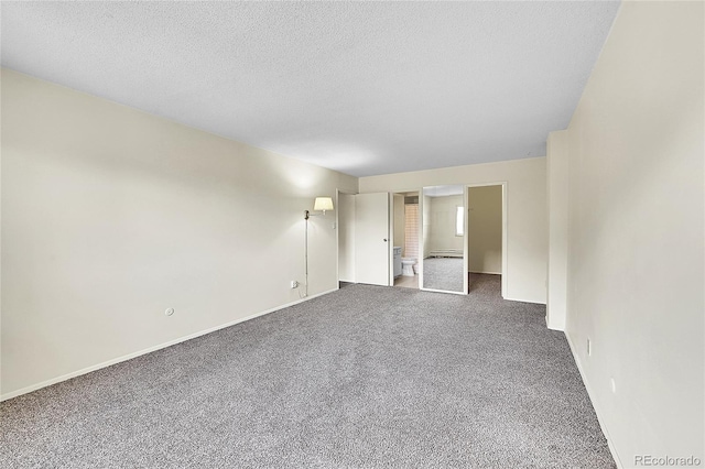 carpeted spare room with baseboards and a textured ceiling